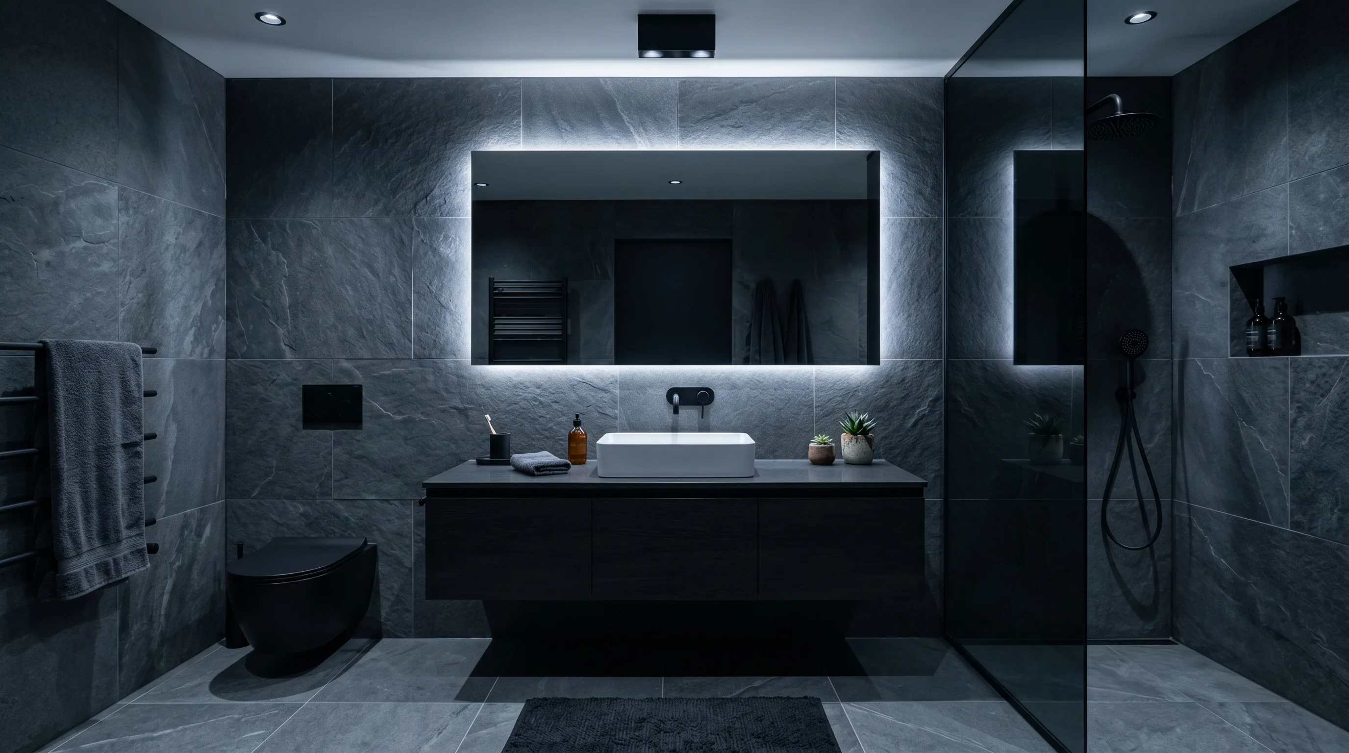 Brass accents warming a dark stone powder room.