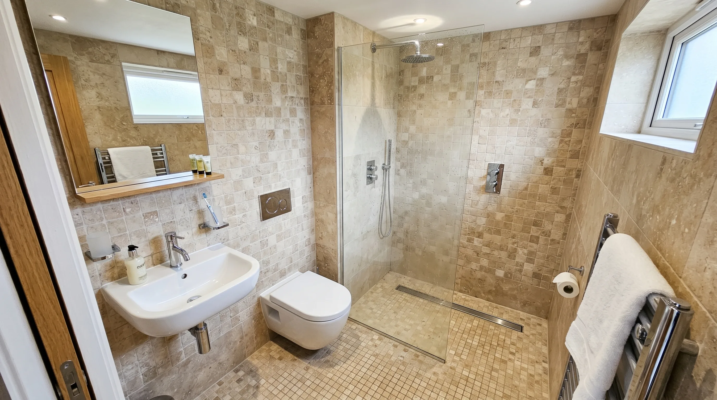 Built-in niche storage in a seamless natural stone bathroom.